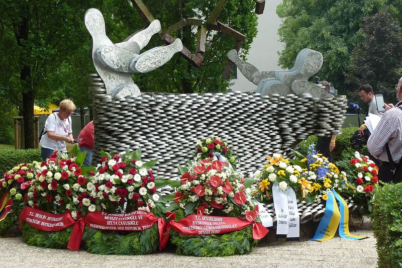 Mit Blumen geschmücktes Mahnmal zum Brand von 1993